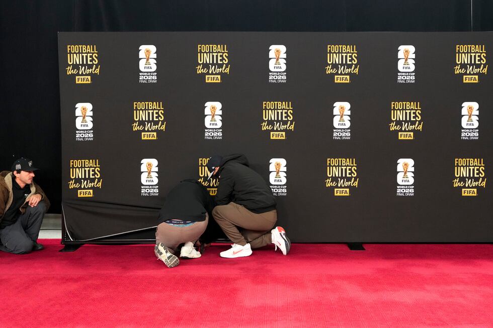 Un grupo de trabajadores prepara la alfombra roja antes del sorteo del Mundial en el Centro...