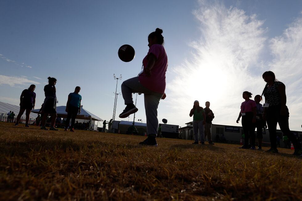 ARCHIVO - Inmigrantes juegan al fútbol en un centro de acogida del gobierno estadounidense...