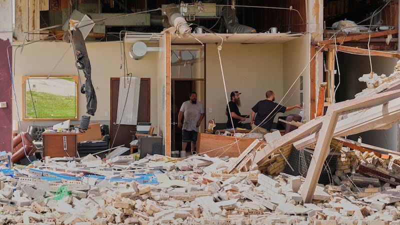 Trabajadores rescatan objetos el martes 14 de abril de 2026 en una fábrica de tuberías dañada...