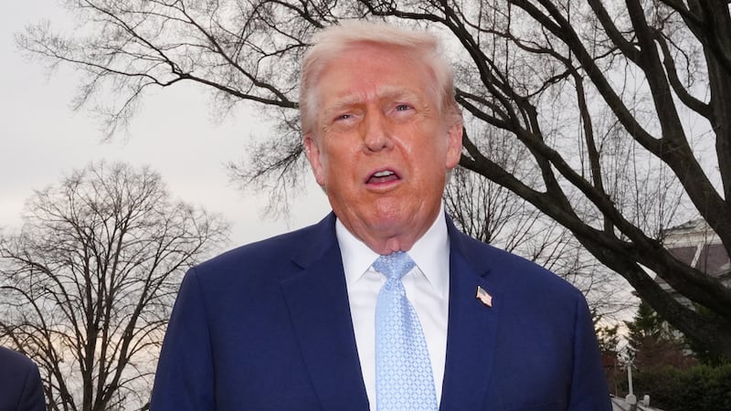 President Donald Trump speaks with reporters before departing on Marine One from the South...