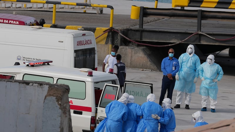 Trabajadores de salud con trajes de protección evacúan pacientes del crucero MV Hondius en una...